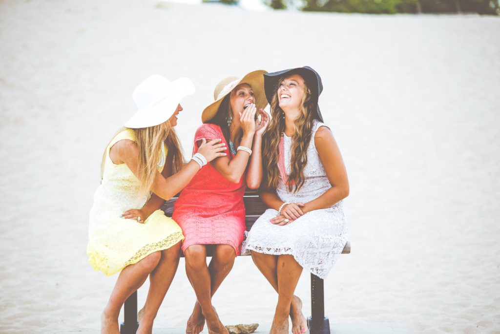 a group of women in bikinis on a beach